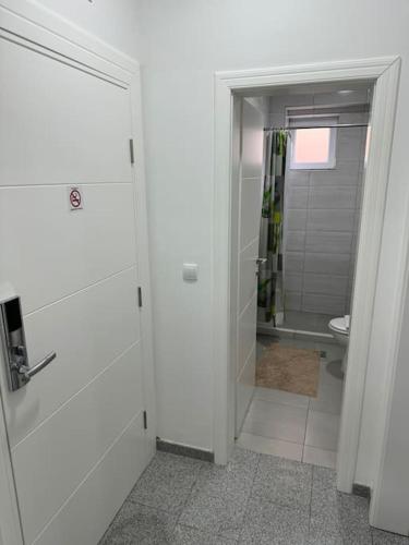 a white bathroom with a shower and a toilet at Lux apartment Bijeljina in Bijeljina