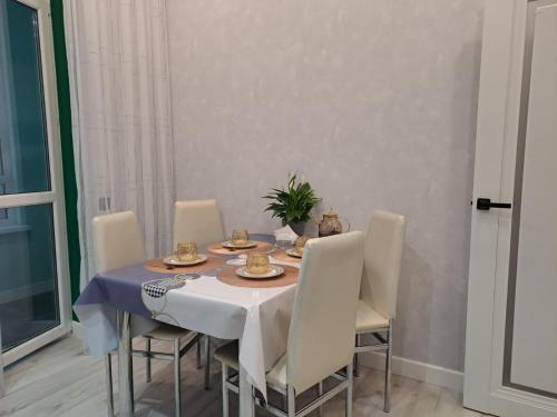 INJU Arena 1-rooms apartments في أستانا: طاولة غرفة الطعام مع مفرش وكراسي زرقاء