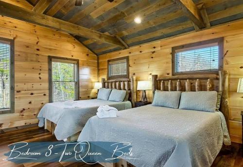 two beds in a log cabin bedroom with wooden walls at Shell Mtn Splash: 4BR Haven, Views, Pool & Hot Tub in Sevierville