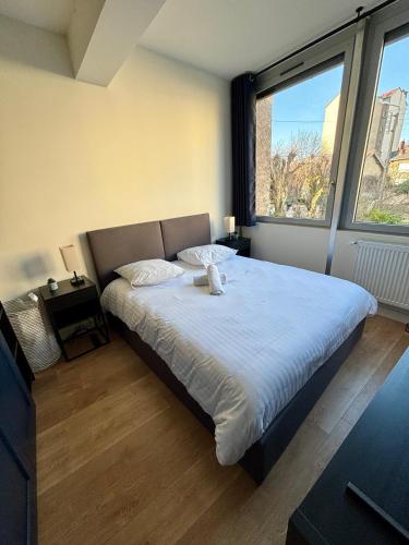 a bedroom with a bed with a teddy bear on it at Le Secret de l'Architecte : proche Centre et Gare in Dijon