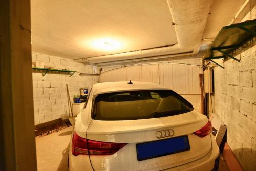 a white car is parked in a garage at La casa di Gloriana [500 metri dalle piste da sci] in Aprica