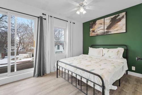 een slaapkamer met een bed met een groene muur bij Beautiful Renovated Oasis in Niagara Falls
