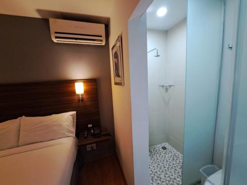 a bathroom with a shower and a bed and a tub at El Hotel Business Class - Zamora Centro in Zamora de Hidalgo