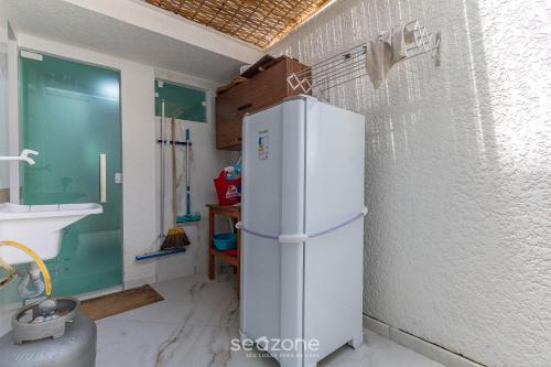 einen weißen Kühlschrank in einer Küche mit Spüle in der Unterkunft Casa Duplex próxima à Praia em Porto - ROC0265 in Porto Seguro