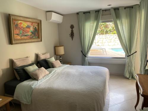 - une chambre avec un grand lit et une fenêtre dans l'établissement Villa Galateias, un coin de Paradis, superbe vue avec piscine, à Cannes