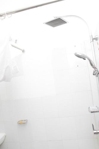 a white bathroom with a shower and a toilet at " Le Nid Douillet ", un fabuleux studio, calme, cosy et bien climatisé au centre de saly in Saly Portudal