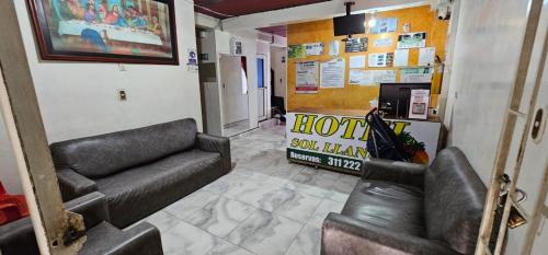 a room with couches and a sign in a hotel room at Hotel Sol Llanero in Yopal