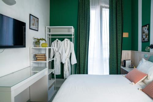 a bedroom with a white bed and green walls at Mare Home Brunch&Beauty - Adults Only in Cesenatico