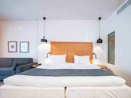 a bedroom with a large bed and a blue couch at Golden Star City Resort in Perea