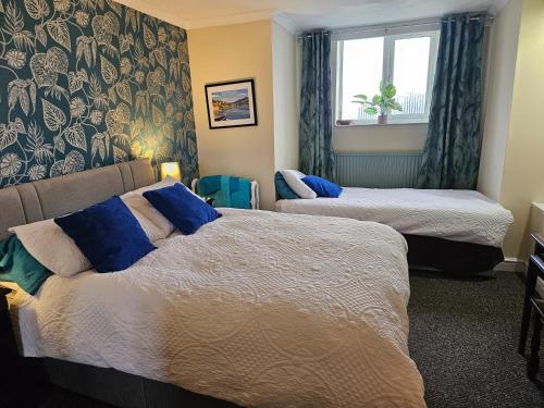 a hotel room with two beds and a window at Talarfor Barmouth in Barmouth