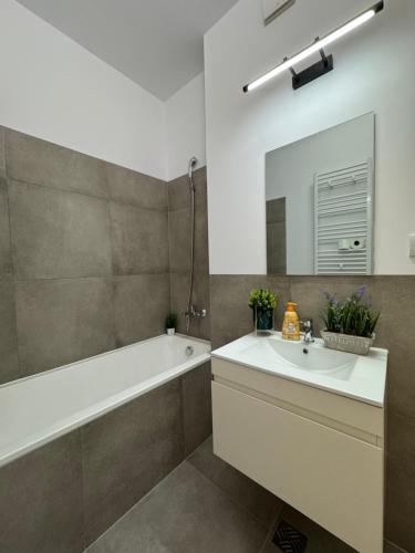 bagno con vasca, lavandino e specchio di Xclusive luxury Silk District a Iaşi