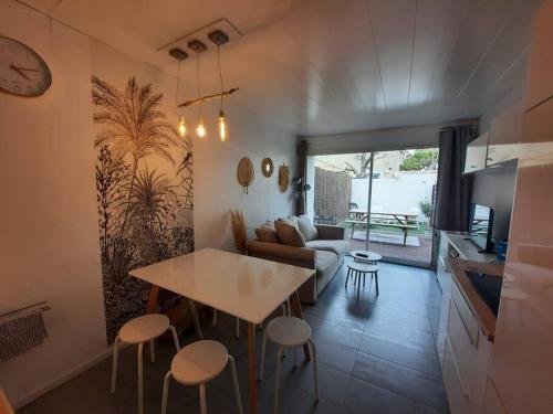 une cuisine et un salon avec une table et des chaises dans l'établissement Carnon plage 3min de la mer! Villa 5 pers Terrasse, à Mauguio