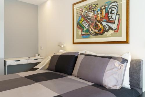 a bedroom with a bed with a painting on the wall at TWINSTAY in Catania