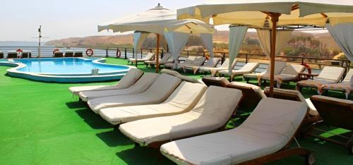 um grupo de cadeiras e guarda-sóis ao lado de uma piscina em NILE CRUISE ND Every Monday from Luxor 4 nights & every Friday from Aswan 3 nights em Aswan