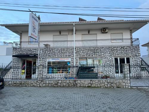 a stone building with a sign on it at Alojamento das Laranjeiras in Fernao Ferro
