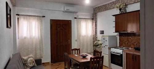 a kitchen with a table and a kitchen with a door at Artan apartment in Vlorë