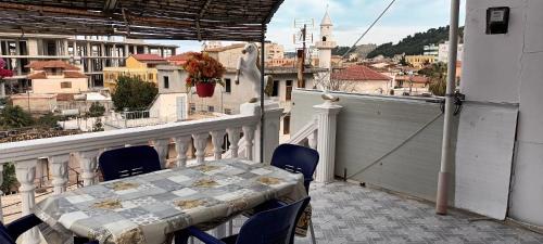 a table on a balcony with a view of a city at Artan apartment in Vlorë