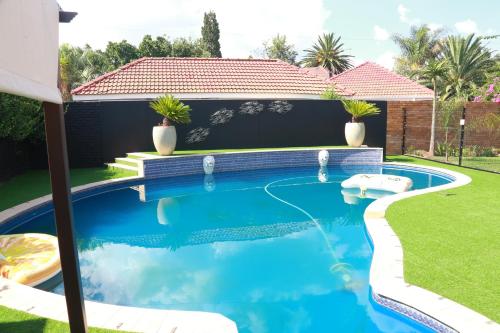 a swimming pool in the yard of a house at Villa Grande Luxury accommodation in Welkom