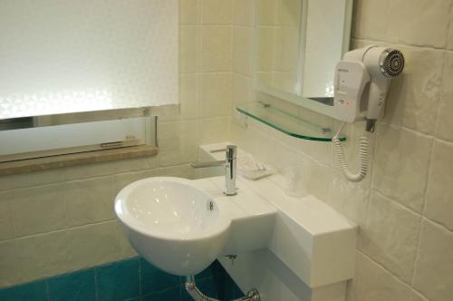 a bathroom with a white sink and a hair dryer at La Madegra Seasuite in Salerno