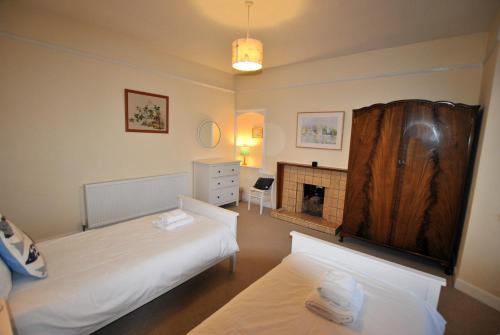 a bedroom with two beds and a fireplace at Stronvar- coastal home with sea views in Pittenweem
