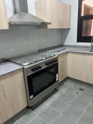 a kitchen with a stove top oven in a kitchen at City Focus ابراج المهلب in Muscat