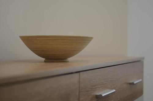 a bowl sitting on top of a wooden dresser at Studi-apartman Kestenov stan in Vršac