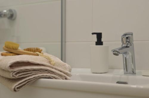 a bathroom sink with a towel and a toothbrush at Studi-apartman Kestenov stan in Vršac