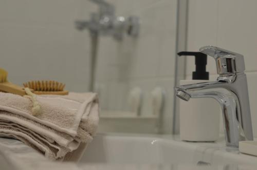 a bathroom sink with a towel and a faucet at Studi-apartman Kestenov stan in Vršac