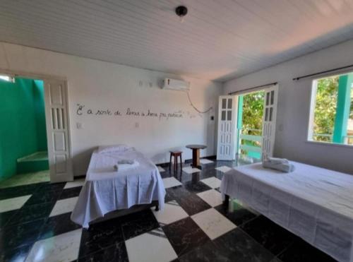 a room with two beds and a checkered floor at Pousada Iakã Boipeba in Cayru