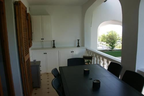 a dining room with a table and chairs and a window at Residence Los Jardines in Alcossebre