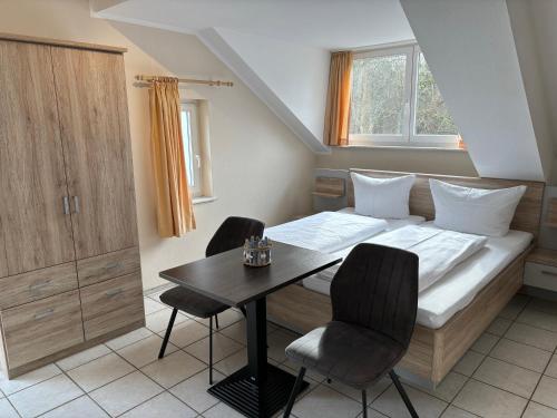 ヘリングスドルフにあるSchmiedehaus - Appartementのベッドルーム1室(ベッド1台、テーブル、椅子付)