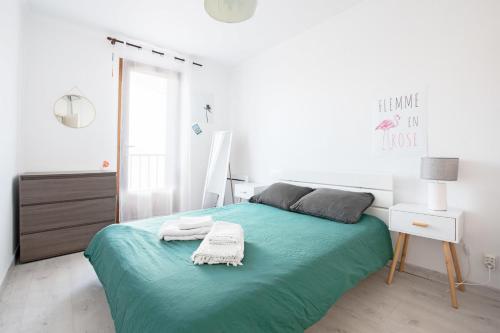 - une chambre blanche avec un lit et une couverture verte dans l'établissement Family cocoon in Carcassonne, à Carcassonne