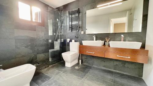 uma casa de banho com 2 lavatórios, um WC e um espelho. em HOUSE WITH PRIVATE GARDEN em Finestrat