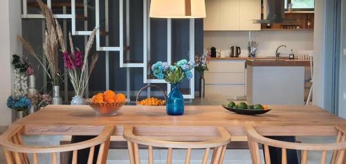 a kitchen with a wooden table with fruits and flowers on it at Physis Villas Chania in Ayiá