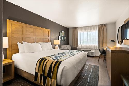 um quarto de hotel com uma cama grande e uma televisão em Oxford Suites Redding em Redding