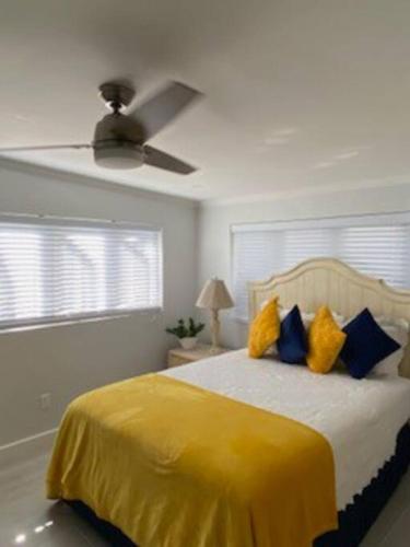 a bedroom with a yellow bed with a ceiling fan at Chez Rose Bungalow in Nassau