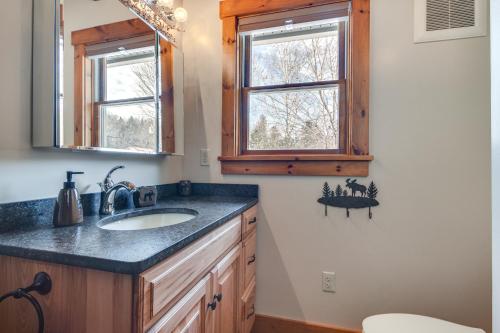 baño con lavabo y 2 ventanas en Lakefront New Hampshire Hideaway with Deck and Views en Errol