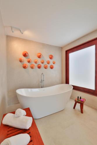 a bathroom with a large white tub and a window at Pousada Tatuá in Pôrto de Pedras