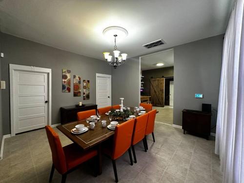 a dining room with a table and orange chairs at Renovated,Comfortable and Convenient Experience in Rocky Mount