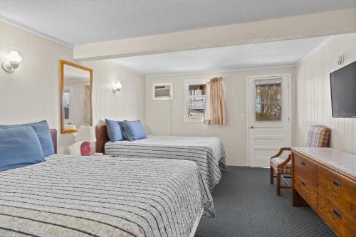 a hotel room with two beds and a desk at Beach Motel and Suites in Old Orchard Beach