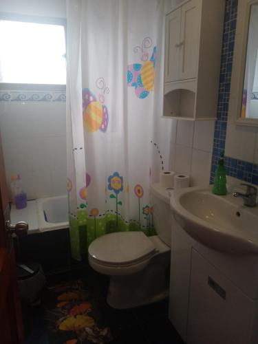 uma casa de banho com um WC e um lavatório em Habitación casa familia em La Serena
