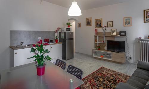 a living room with a table and a kitchen at All'ombra del Campanile in Volterra