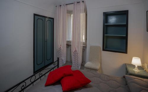 a bedroom with a bed with a red pillow on it at All'ombra del Campanile in Volterra