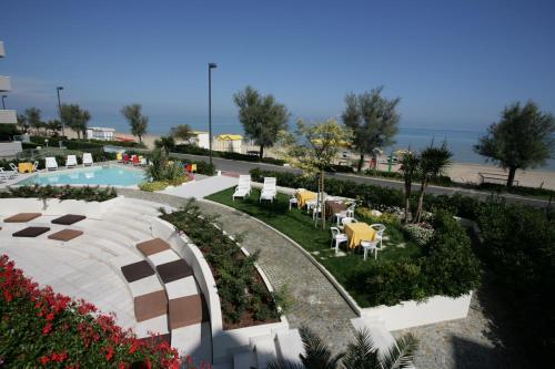 Vistas a un complejo con piscina, mesas y sillas en Hotel Ruhig, en Marotta