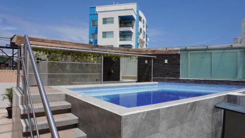 una piscina con escaleras junto a un edificio en YORMARI HOTEL, en Manta