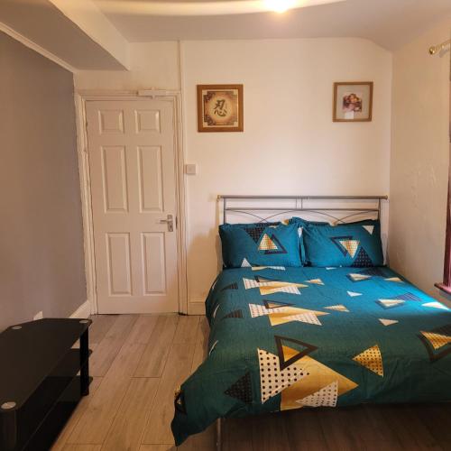 1 dormitorio con 1 cama con edredón azul en PIEDMONT ROAD en Londres