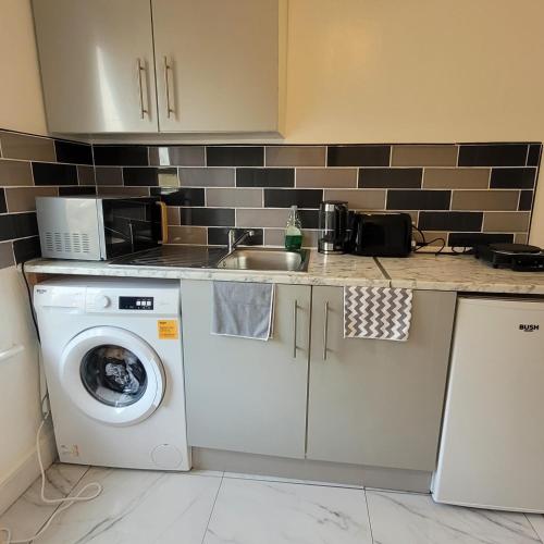 a kitchen with a washing machine and a sink at PIEDMONT ROAD in London