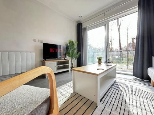 a living room with a table and a large window at Luxury Canal-side Apartment, Hemel Hempstead, Free parking, Perfect for Contractors in Hemel Hempstead