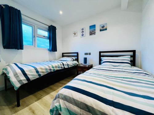 - une chambre avec 2 lits et une fenêtre dans l'établissement 2 bedroom Scratby chalet holiday park close to beach, à Scratby