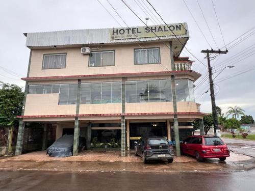 un hotel con dos coches estacionados frente a él en Hotel Shalon en Rio Branco